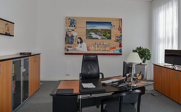 Blick über Schreibtisch des Landtagspräsidenten auf ein Bild an der Wand