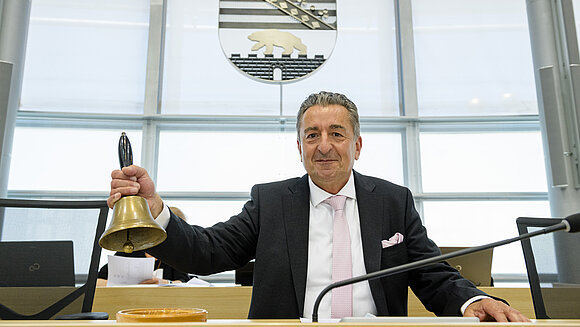 Landtagspräsident Schellenberger mit Glocke in der Hand.