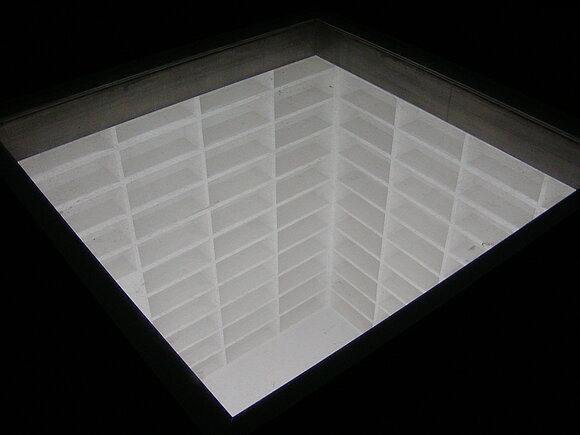 Denkmal für die Bücherverbrennung in Berlin. Es zeigt einen unterirdischen Raum mit leeren Bücherregalen.