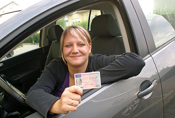 Eine junge Frau hat gerade ihren Führerschein erhalten.
