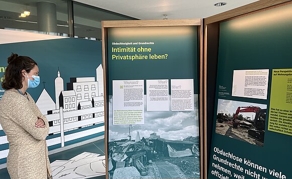 Besucherin schaut sich Tafeln der Ausstellung an.