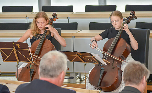 Blick auf zwei junge Celistinnen, die während der Feierstunde im Plenarsaal musizierten.