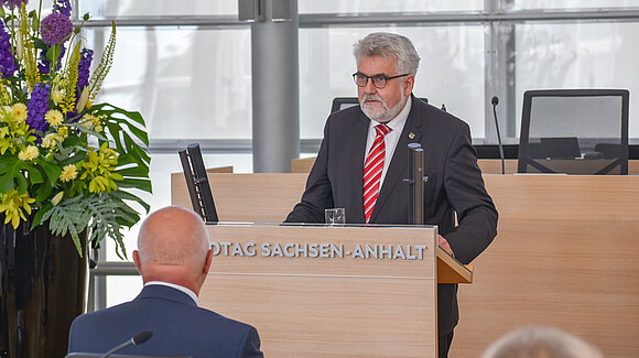 Minister Prof. Dr. Armin Willingmann während seiner Rede beim Festakt zu „30 Jahre Landesverfassung“ am Rednerpult im Plenarsaal.