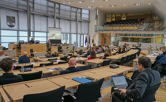 Blick in den Plenarsaal, wo Abgeordnete und Architekten Platz genommen haben.