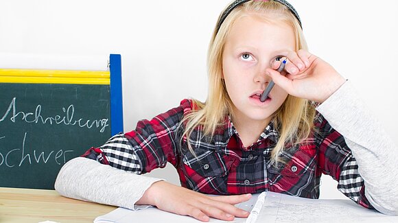 st-fotograf - fotolia.com Schülerin sitzt über Aufgabe, kaut an Bleistift und schaut nachdenklich