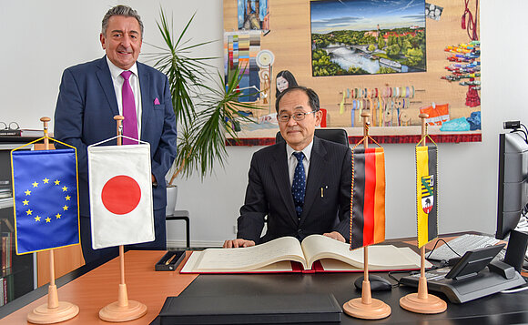 Japans Botschafter Yanagi und Landtagspräsident beim Eintrag ins Gästebuch des Landtags von Sachsen-Anhalt.