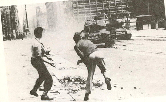 Aufgebrachte Demonstranten werfen am 17. Juni 1953 Steine auf Panzer.