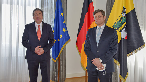 ltlsa/stb Landtagspräsident (l.)und Gesandter stehen vor Fahnen