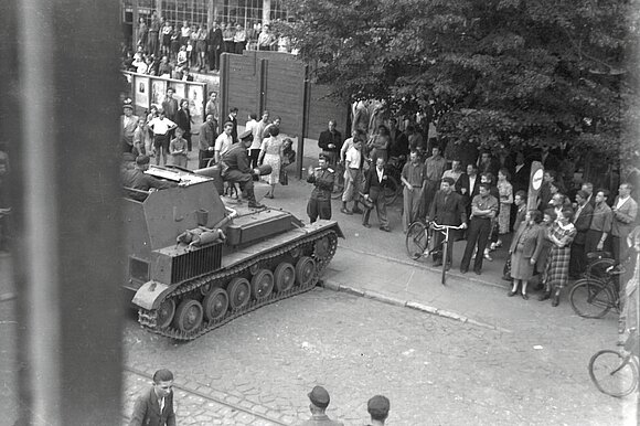 Schönebeck, 17. Juni 1953: Vor der SED-Kreisleitung (Bahnhofstraße 11) haben sich protestierende Menschen versammelt. Ein sowjetischer Panzer versucht die Menge auseinanderzutreiben.