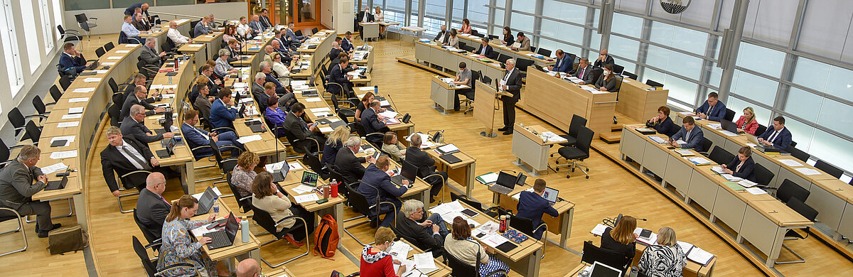 Blick von der Pressetribüne in den Plenarsaal, in dem Abgeordnete sitzen