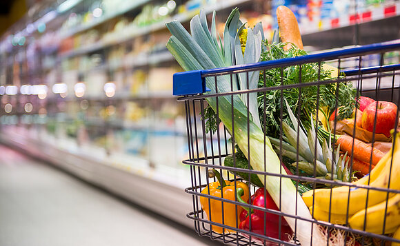 Gefüllter Einkaufskorb in einem Laden ohne Mitarbeitende nach der Schließzeit.
