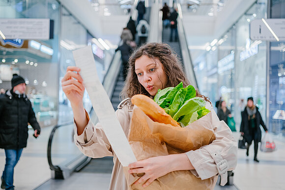 wifesun - stock.adobe.com Die Verbraucherpreise steigen, ein deutliches Zeichen für die steigende Inflation. Symbolbild: Frau mit Kassenzettel und leerer Einkaufstüte.