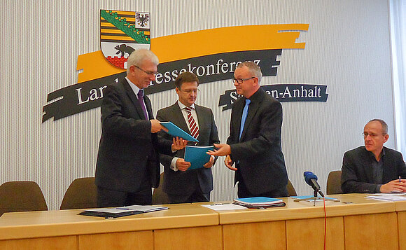 Univ.-Prof. Dr. med. Hans-Henning Flechtner (r.) überreicht als Ausschussvorsitzender den aktuellen Bericht an Landtagspräsident Detlef Gürth (M.) und Sozialminister Norbert Bischoff.