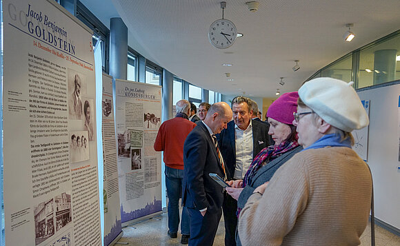 Zwei Frauen blicken stehend auf eine der Ausstellungstafeln