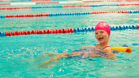 Tobilander/fotolia.com Kleines Mädchen lernt schwimmen in Schwimmbecken.