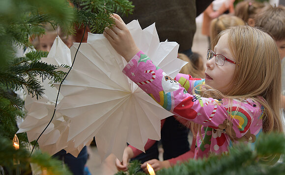 Mädchen beim Schmücken des Weihnachtsbaums im Foyer des Landtags.