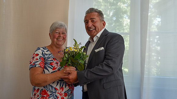 Dr. Schellenberger gratuliert Gabriele Brakebusch mit einem Blumenstrauß