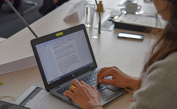 Hände tippen auf der Tastatur eines Laptops