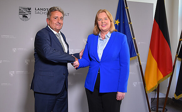 Landtagspräsident Dr. Gunnar Schellenberger begrüßt Bundestagspräsidentin Bärbel Bas mit Handschlag vor Fahnen.