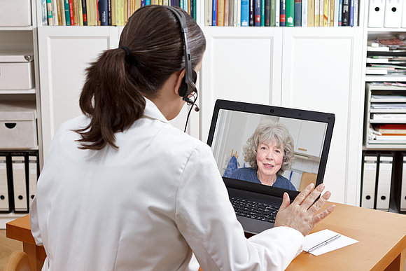 Medizinerin unterhält sich in einem Videochat mit einer Patientin.