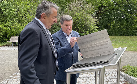 Landtagspräsident Schellenberger und Dieter Steinecke vom Volksbund schauen sich die Liste jener Soldaten an, die auf dem „Feld der Vereinten Nationen“ auf dem Friedhof Magdeburg-Westerhüsen bestattet sind.