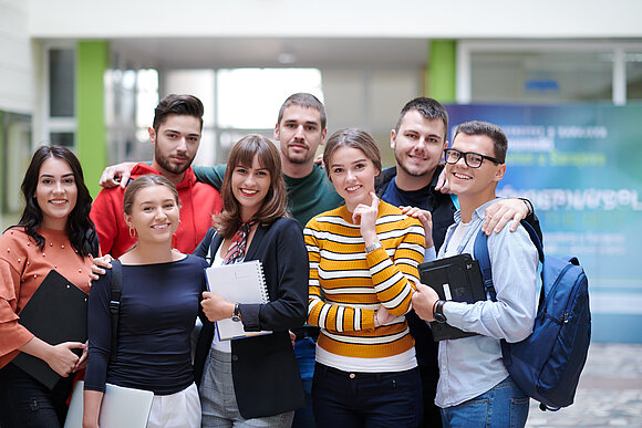 .shock/stock.adobe.com Gruppen von Studenten steht im Flur der Uni