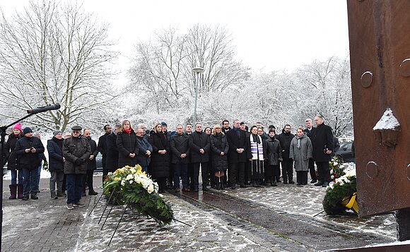 Die Anwesenden stehen vor dem Mahnmal