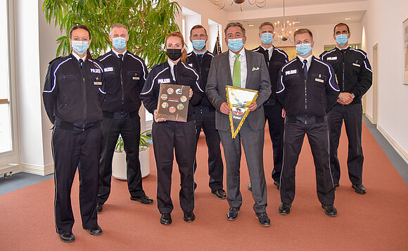 Eine Gruppe von Polizistinnen und Polizisten hat für ein gemeinsames Foto mit Landtagspräsident Schellenberger Aufstellung genommen.