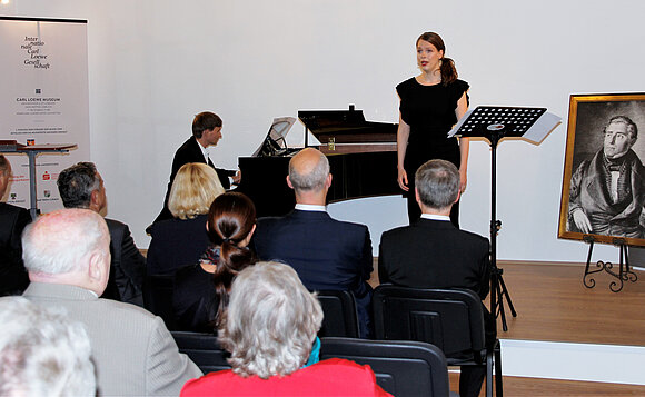 Anna Schors (Gesang) und Paul Heller (Klavier) auf der Bühne. Sie schufen den musikalischen Rahmen der Eröffnungsveranstaltung.