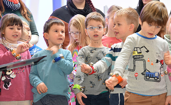 Kinder mit Glöckchen singen „Kling Glöckchen“.