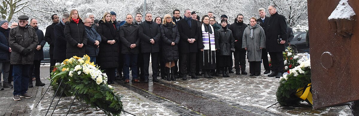 Die Anwesenden stehen vor dem Mahnmal