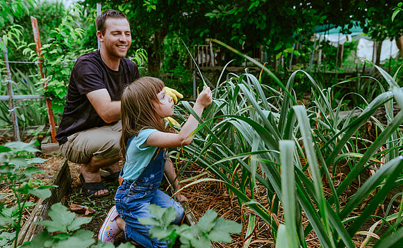 Vater und Tochter arbeiten zusammen im heimischen Garten.