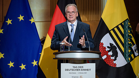 Ministerpräsident Reiner Haseloff spricht am Rednerpult am Tag der Deutschen Einheit.