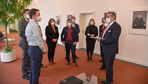 Abgeordnete, Landtagspräsident und zwei Petenten stehen im Halbkreis