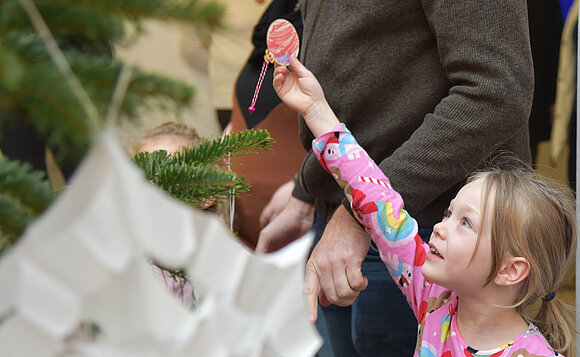 Mädchen beim Schmücken des Weihnachtsbaums im Foyer des Landtags.
