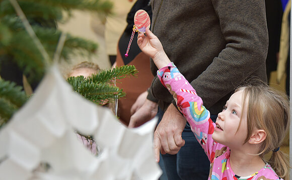 Mädchen beim Schmücken des Weihnachtsbaums im Foyer des Landtags.