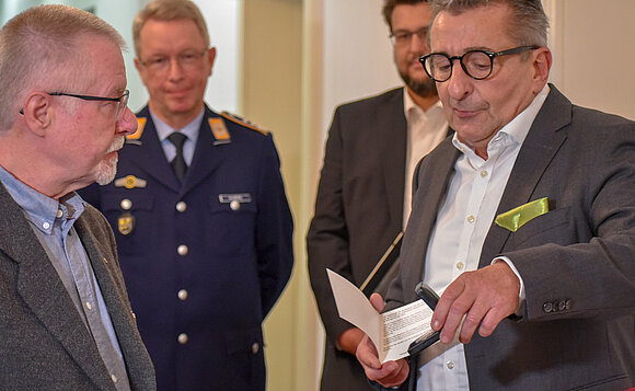 Landtagspräsident überreicht Medaille an den Vater eines Soldaten.