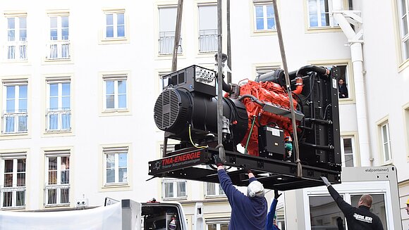 ltlsa Ein großer roter Dieselgenerator an einem Kranhaken