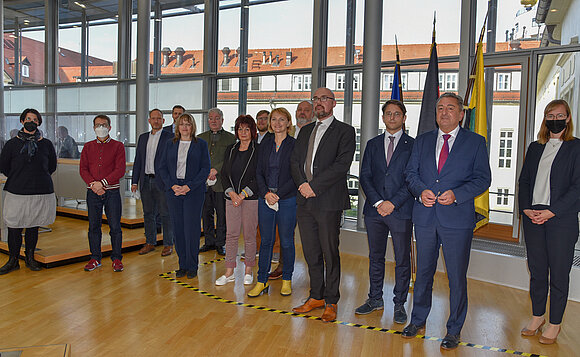 Gruppe von Abgeordneten steht im Plenarsaal des Landtags