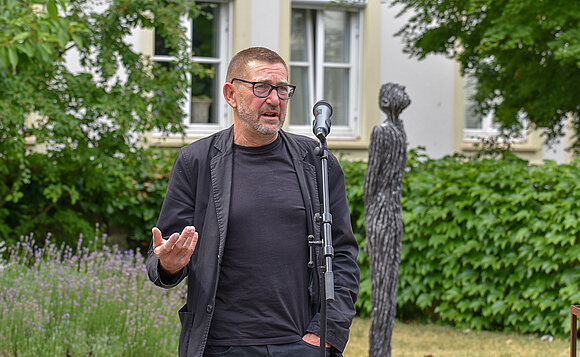 Der Künstler Matthias Trott sprach zur Eröffnung seiner Ausstellung am Mikrofon im Innenhof des Landtags von Sachsen-Anhalt.