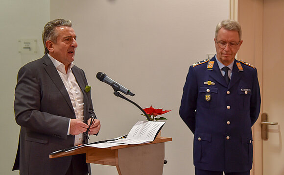 Landtagspräsident steht hinter Mikrofon, neben ihm der Chef des Landeskommandos Sachsen-Anhalt