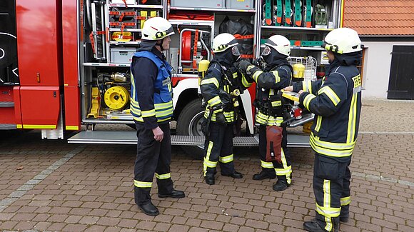 Feuerwehrleute bereiten sich auf ihren Einsatz vor.