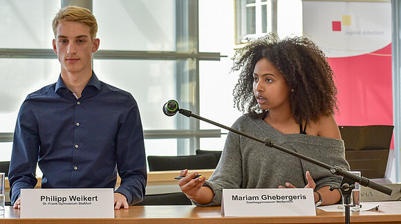 Zwei Teilnehmende von Jugend debattiert im Plenarsaal im Jahr 2021.