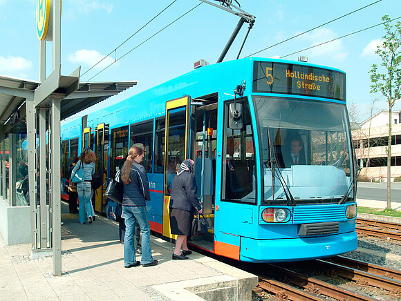 Leute steigen in eine Straßenbahn ein.