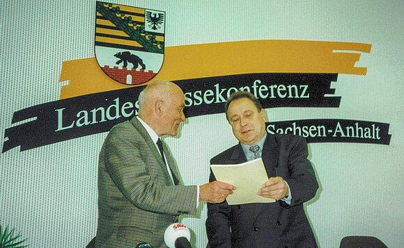 Ministerialrat a.D. Prof. Dr. Hans Heinze überreicht Landtagspräsident Klaus Keitel 1997 den aktuellen Bericht des Ausschusses.