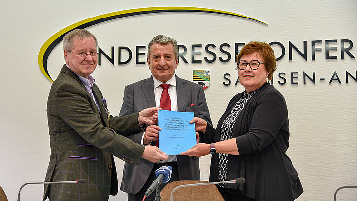 Der Ausschussvorsitzende Prof. Dr. Henning Flechtner (l.) übergibt den 29. Bericht an Landtagspräsident Dr. Gunnar Schellenberger und Sozialministerin Petra Grimm-Benne.