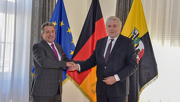 ltlsa/stb Präsident begrüßt Botschafter mit Handschlag vor Flaggen