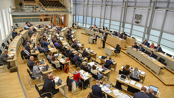 Blick von der Pressetribüne in den Plenarsaal, in dem Abgeordnete sitzen