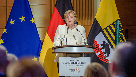 Bundeskanzlerin Angela Merkel spricht am Rednerpult in der Händelhalle Halle (Saale) zum Tag der Deutschen Einheit.