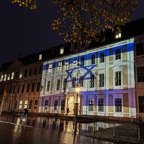 Landtagsgebäude abends illuminiert mit Nationalfahne Israels